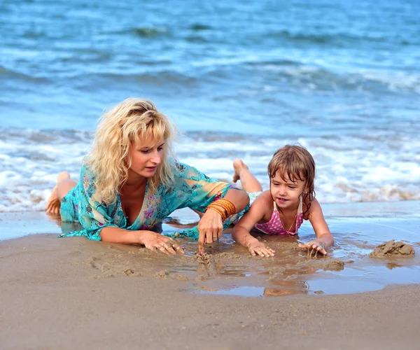 Moeder met dochter op strand — Stockfoto