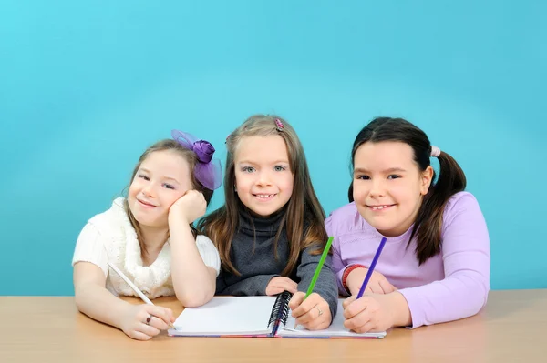 Glad skolflickor gör sitt arbete i klassrummet — Stockfoto