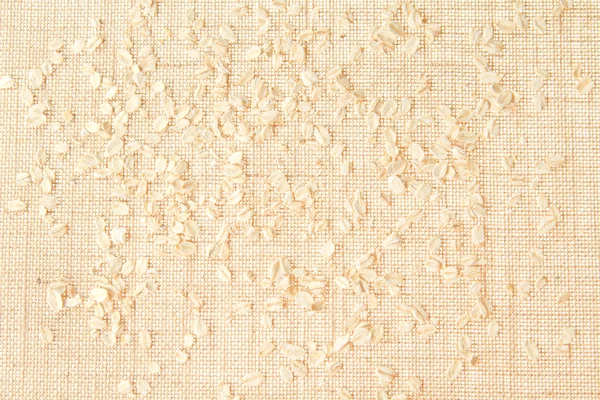 Burlap texture with scattered cereal grains — Stock Photo, Image