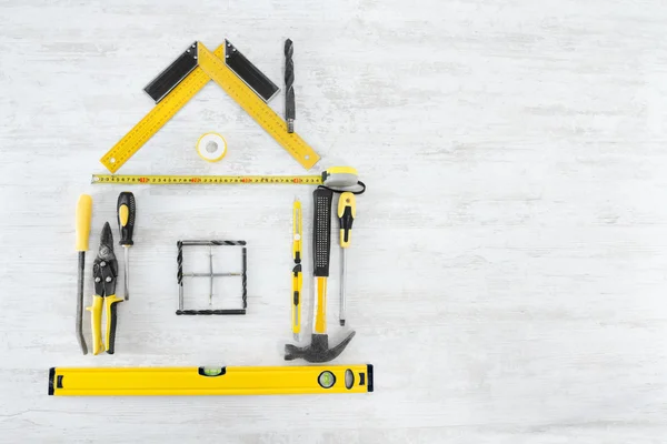 Werkzeuge Form des Hauses, zu Hause verbessern und Reparatur-Konzept. weißer Holzhintergrund — Stockfoto