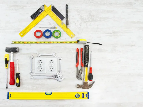Tools in the shape of house over wooden background. Home improving, repair concept. — Stock Photo, Image