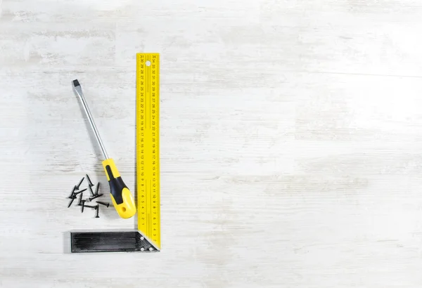 Screwdriver with screw and ruler — Stock Photo, Image