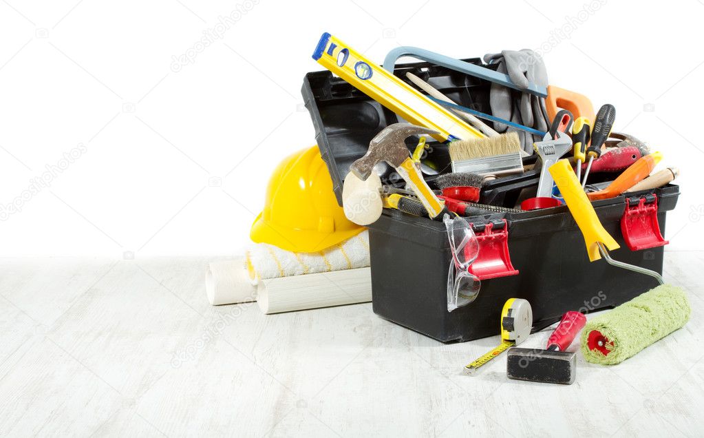 Tools in toolbox over wooden floor against empty wall. Copy spac