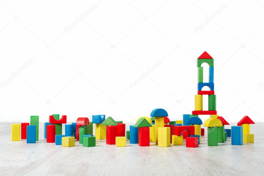 Building blocks toy over floor in white empty interior. Children