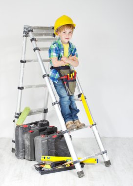 Little boy handyman with helmet and tool belt on stepladder clipart