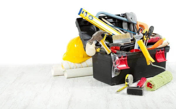 Tools in toolbox over wooden floor against empty wall — ストック写真