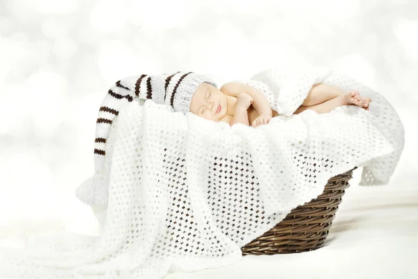 Спящий младенец в шерстяной шляпе лежит в корзине с одеялом — стоковое фото