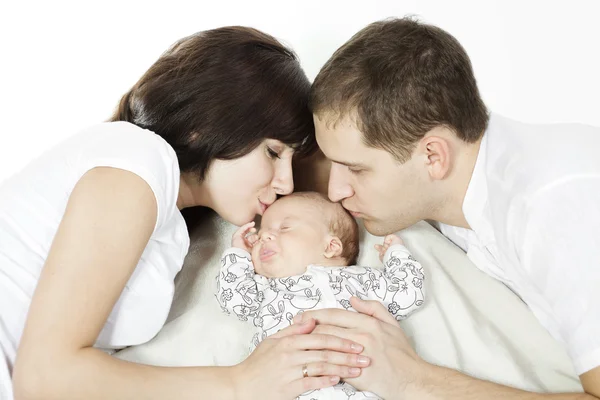 両親は生まれたばかりの赤ちゃんにキスします。家族愛 — ストック写真