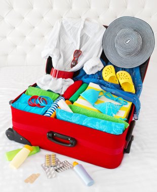 Travel suitcase packed for vacation with personal belongings clipart