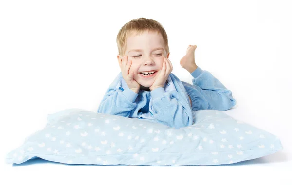Niño sonriente acostado con almohada — Foto de Stock