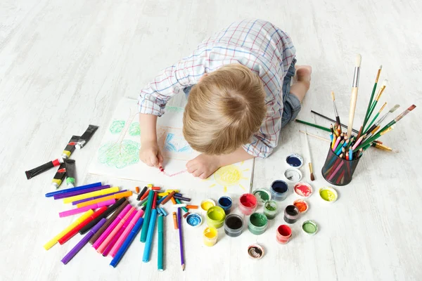 Bambino disegno con pastello in album con un sacco di vernice — Foto Stock
