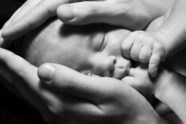 Bebê recém-nascido dormindo nas mãos dos pais. Conceito: crianças protecti — Fotografia de Stock