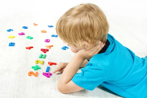 A criança resolve o exemplo matemático. À procura de resposta . — Fotografia de Stock