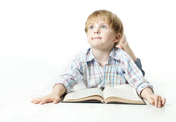 Barn läser bok och drömmer liggande över vita — Stockfoto