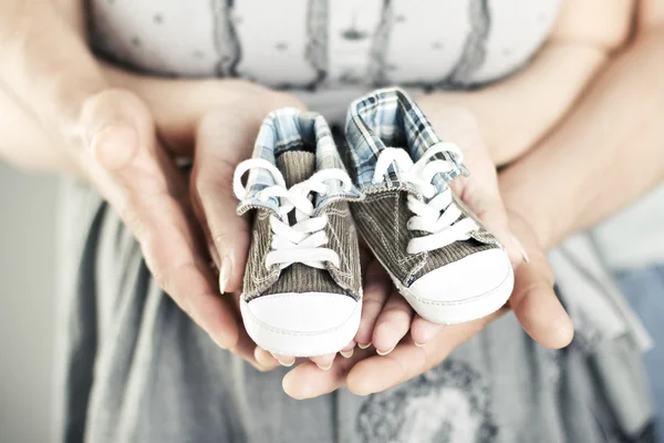 Recién nacido bebé botines en padres manos — Foto de Stock
