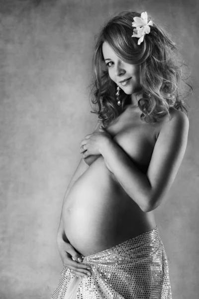 Pregnant woman smiling, looking at camera. Monochrome. Low key — Stock Photo, Image