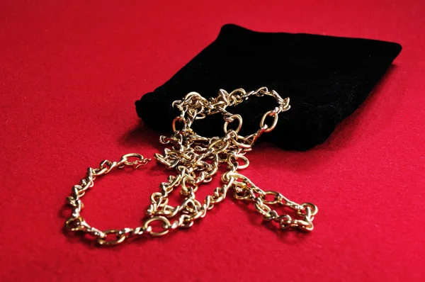 Золотое ожерелье с черной сумкой — стоковое фото