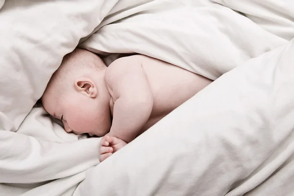 Babyjongen in dekbedovertrekken — Stockfoto