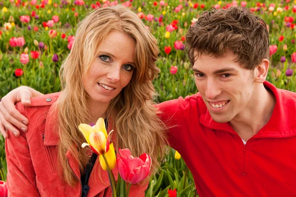 Νεαρό ζευγάρι στην ολλανδική λουλούδι πεδία — Φωτογραφία Αρχείου