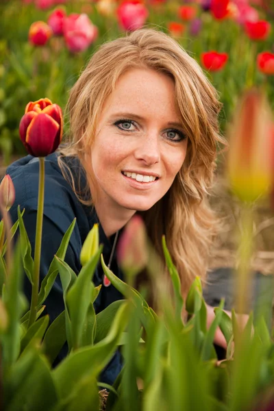 Dutch blond girl in field with tulips — Stock Photo, Image