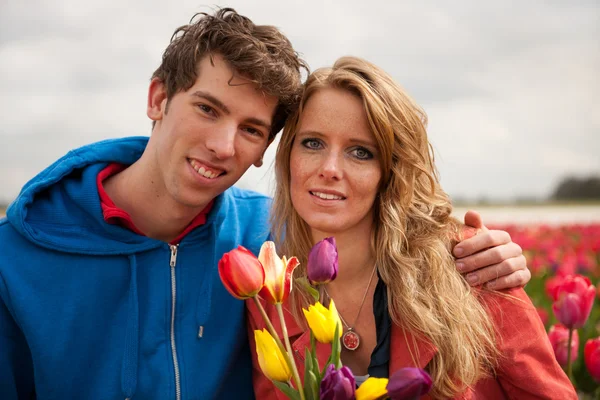 Ungt par i nederländska blomma fält — Stockfoto