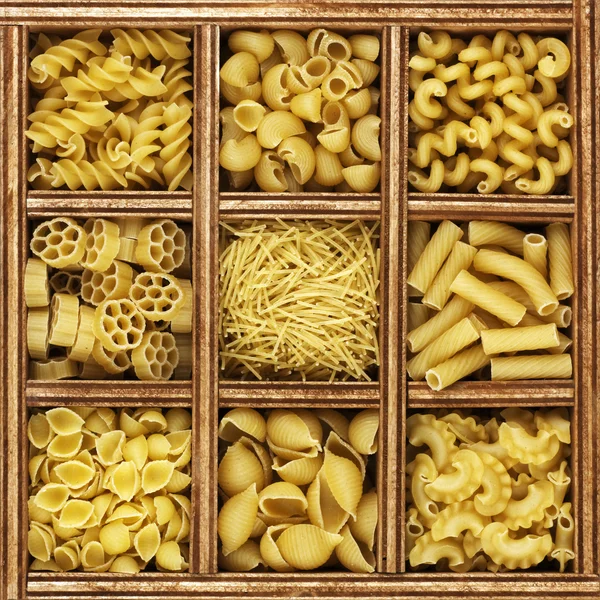 Verschillende soorten Italiaanse pasta in houten kist catalogus — Stockfoto
