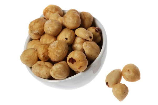 Kleine witte kop vol unshelled hazel noten — Stockfoto