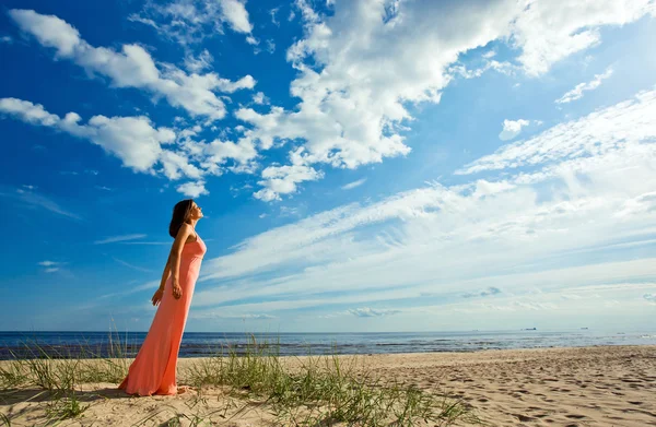 Γυναίκα σε ροζ φόρεμα στην παραλία — Φωτογραφία Αρχείου