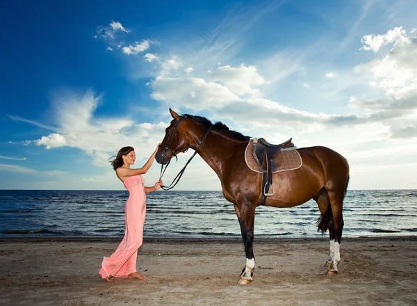 Красива дівчина з конем на морі — стокове фото