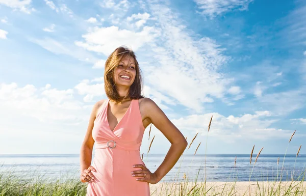 Sahil üzerinde pembe elbiseli kızın — Stok fotoğraf