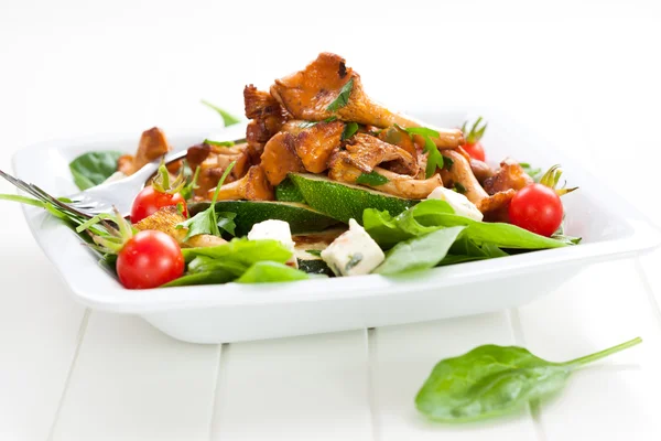 Fresh baby spinach with roasted chanterelle mushrooms — Stock Photo, Image