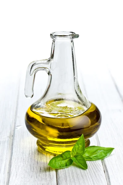Оливковое масло с листьями базилика — стоковое фото