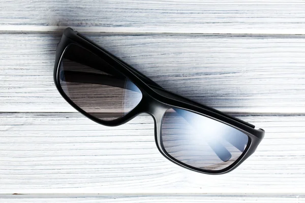 Sonnenbrille auf weißem Holzboden — Stockfoto