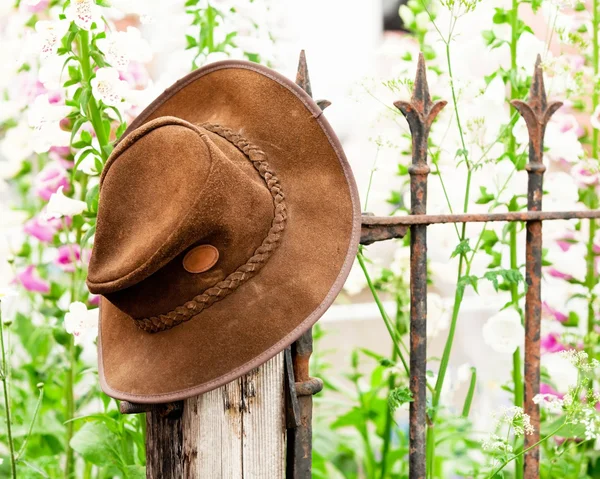 Stock image Bush hat on a railing with flowers