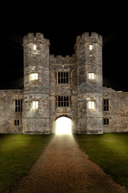 Old castle at night with lights shining through windows clipart