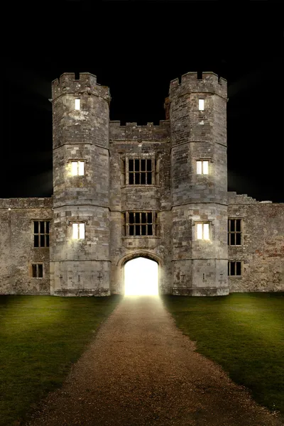 Old castle at night with lights shining through windows — Stock Photo, Image