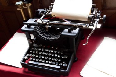 Old typewriter and paper on writers desk clipart