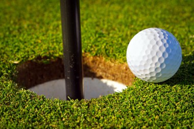 Golf ball near the hole clipart