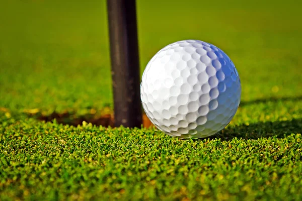 Piłka golfowa w pobliżu otworu — Zdjęcie stockowe