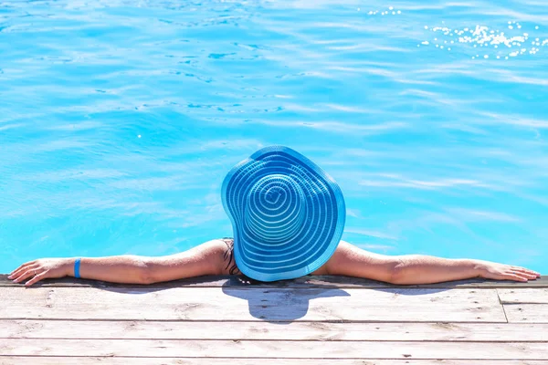 Mujer en sombrero relajante en la piscina popó — Foto de Stock