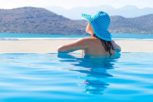 Mulher de chapéu relaxante na natação poo — Fotografia de Stock