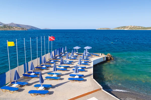 Blauwe deckchairsat Egeïsche zee — Stockfoto
