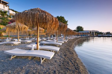 Sunbeds with parasols at Mirabello Bay
