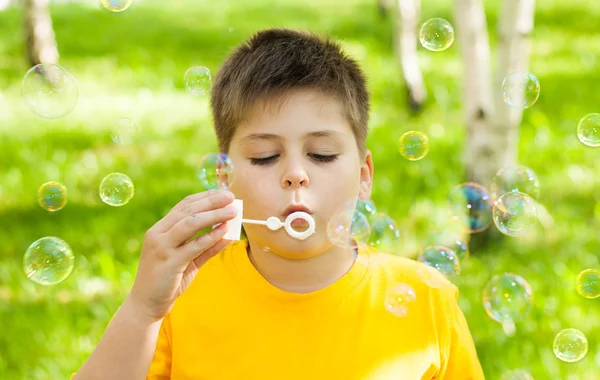 stock image The boy blow bubbles at the park