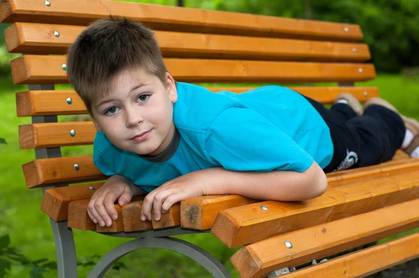 Il ragazzo giaceva su una panchina — Foto Stock