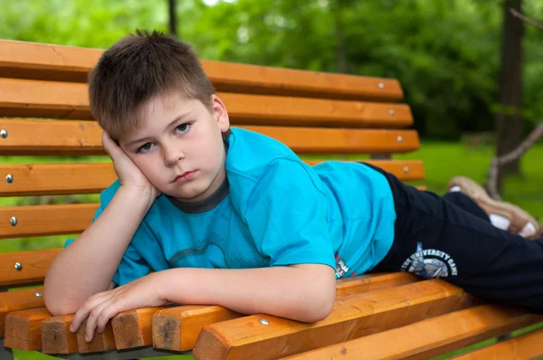 Smutný kluk na lavičce — Stock fotografie