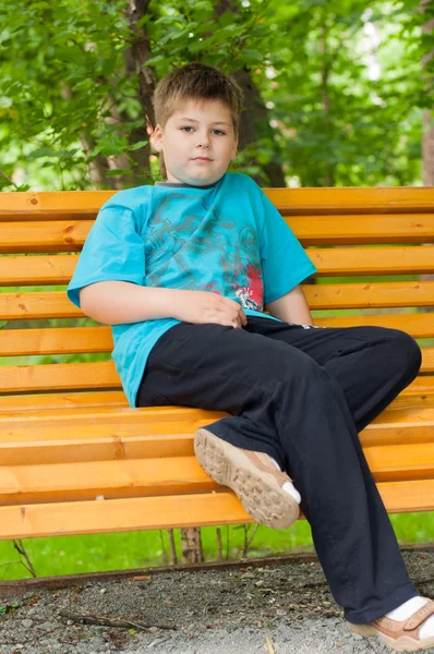 Trieste jongen op een bankje — Stockfoto