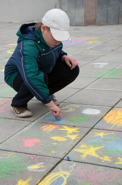 stock image A boy paints chalk on the pavement