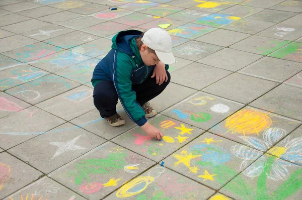 Ein Junge malt Kreide auf den Bürgersteig — Stockfoto