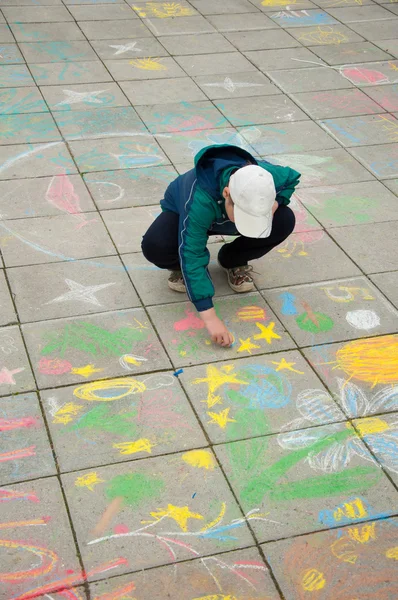 Ένα αγόρι χρώματα κιμωλία στο πεζοδρόμιο — Φωτογραφία Αρχείου